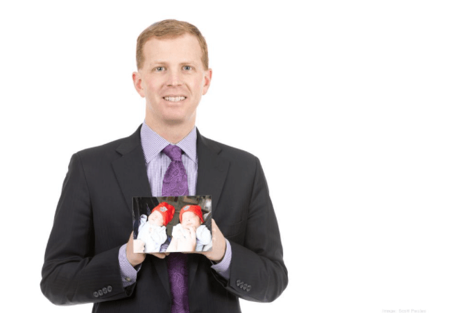 Matt Wolfert holding picture of twin children