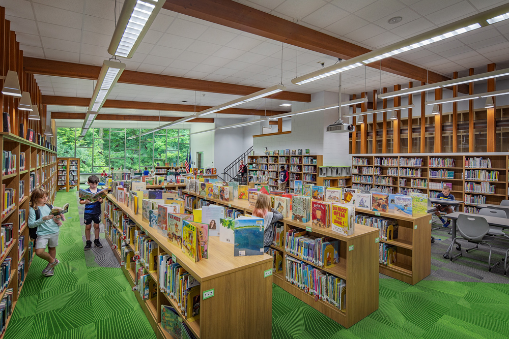 Lush greens in the carpet and outside a wall of windows give an inviting feel to the library at Canterbury Elementary in Greendale