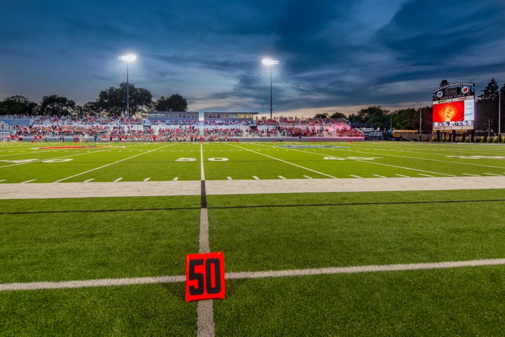 Wide view of football stadium at dusk from 50 yard line