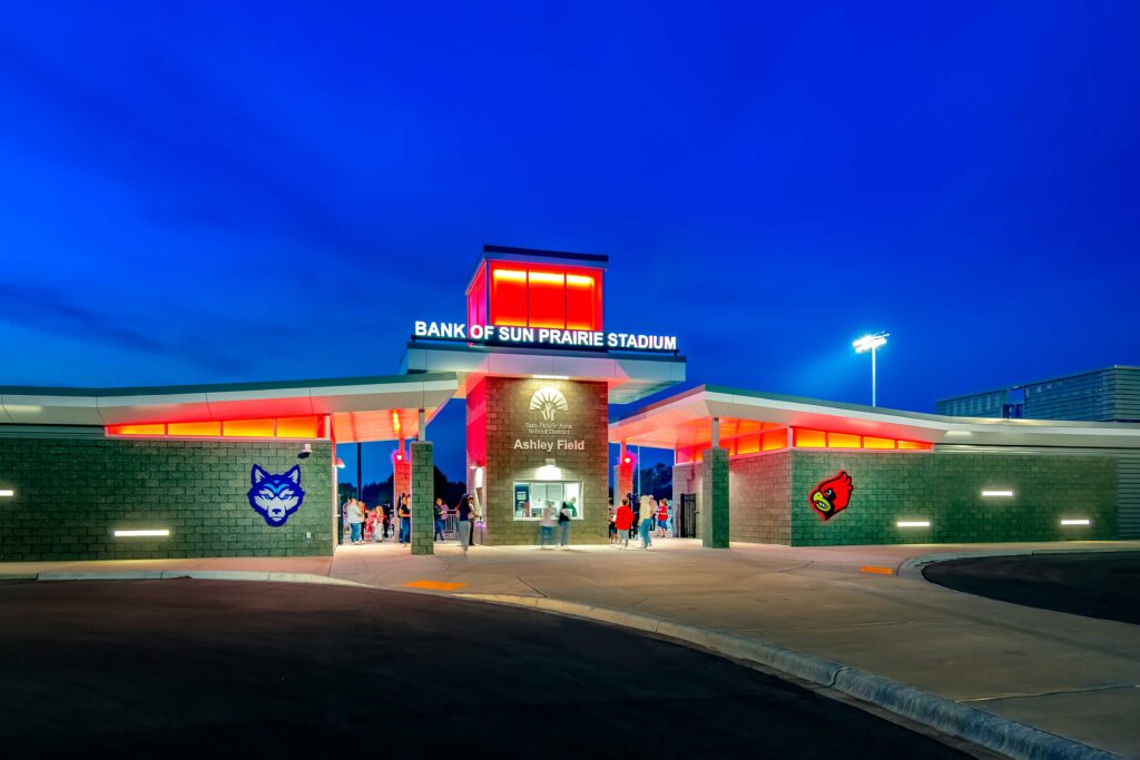 Stadium entrance is lit in red at dusk