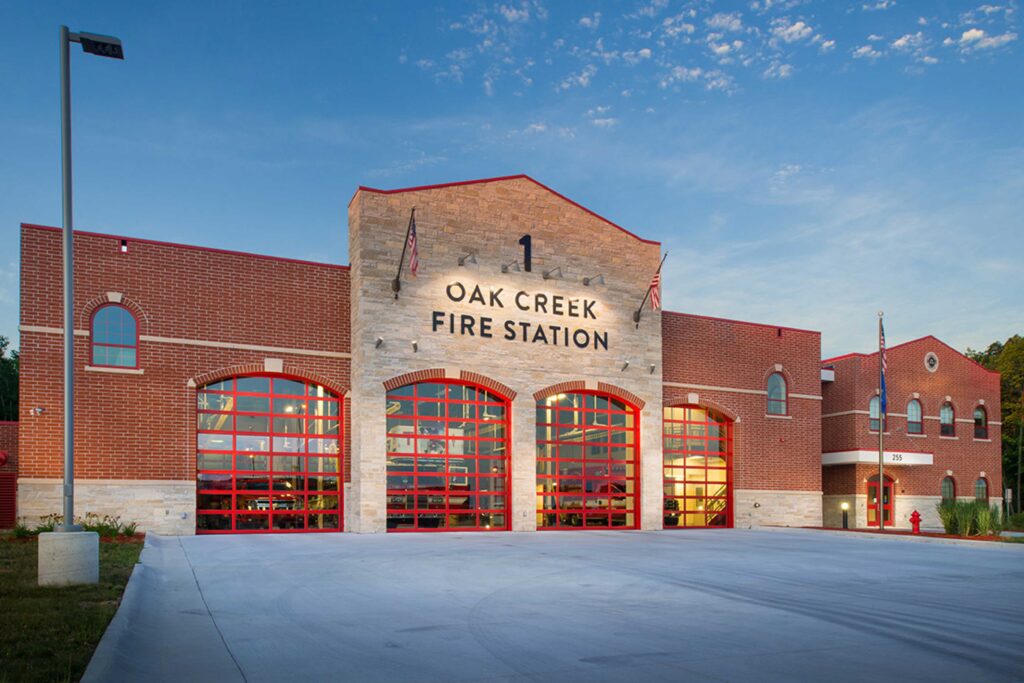 View from the exterior of a four-bay, stone-and-brick fire station in the City of Oak Creek