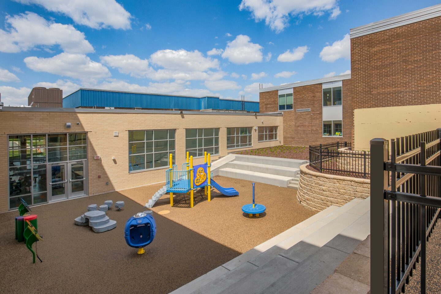 Playgrount equipment nestles into a courtyard flanked by a new addition at Belleville Intermediate School