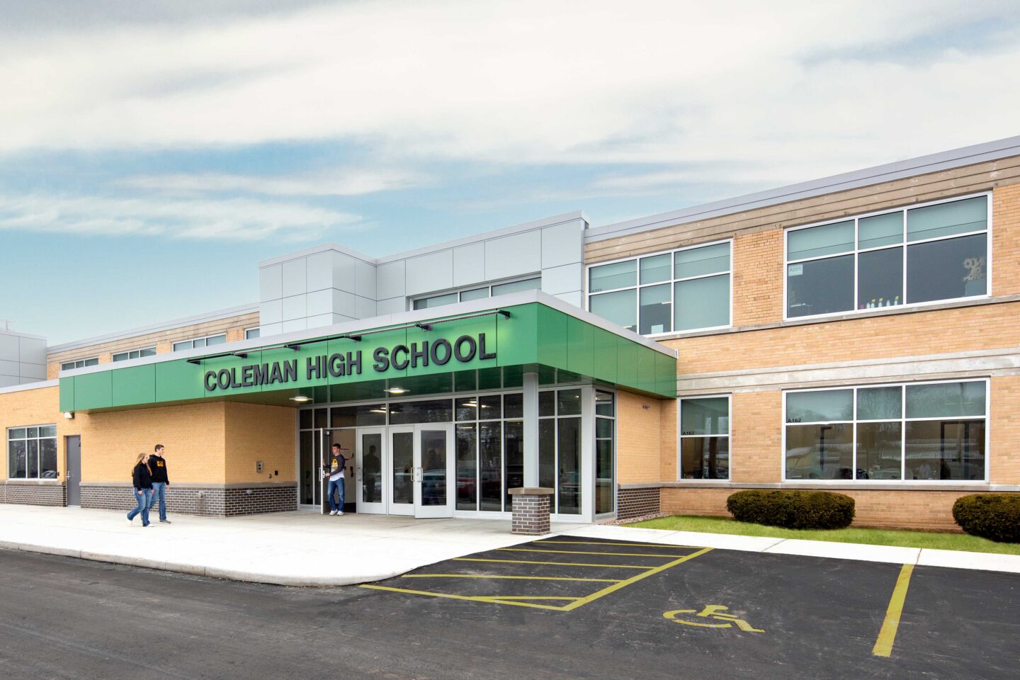 Exterior view of the updated entrance to Coleman High School, which bumps out from the existing building and is accented by school colors