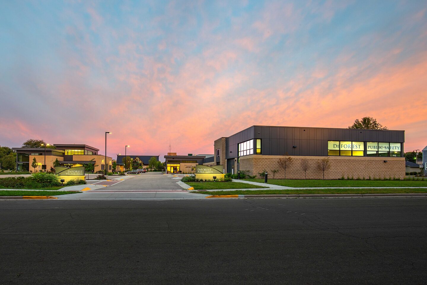 View at dusk from across the street of a public safety building and village hall complex in DeForest