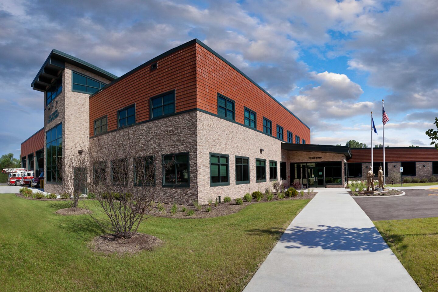 Wide exterior perspective of a modern public safety building and surrounding landscaping in Delafield