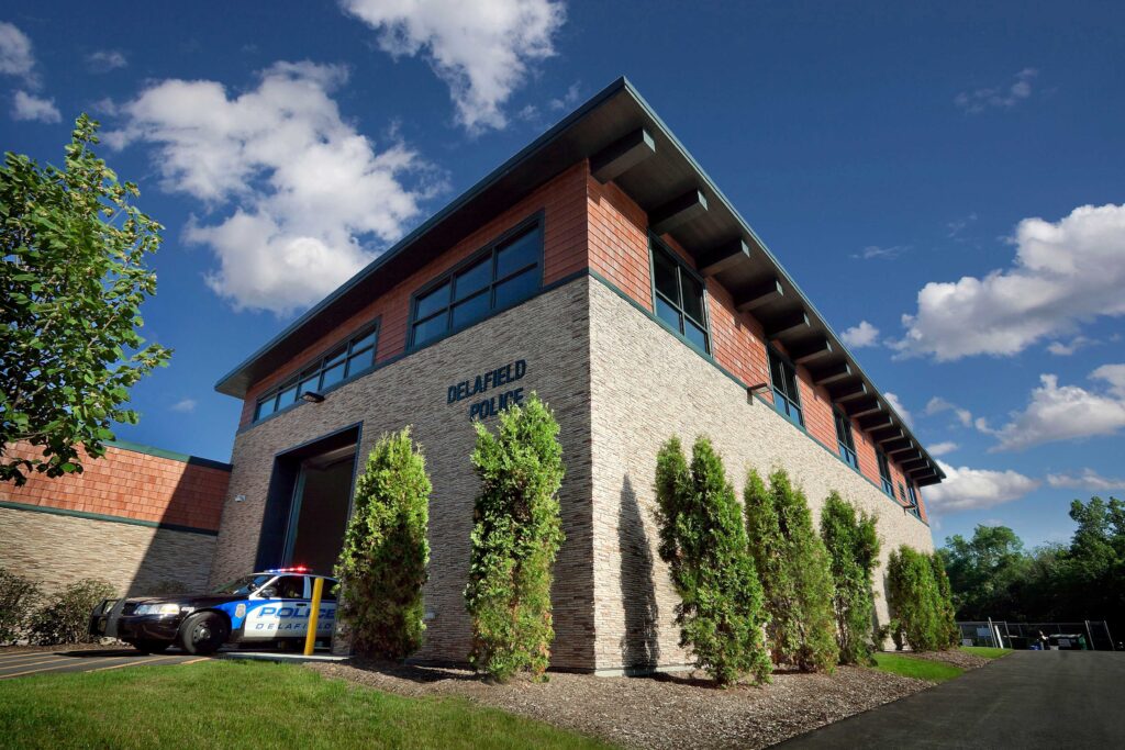 Upward view of the corner of the public safety building, with a Delafield police car peeking out of a bay