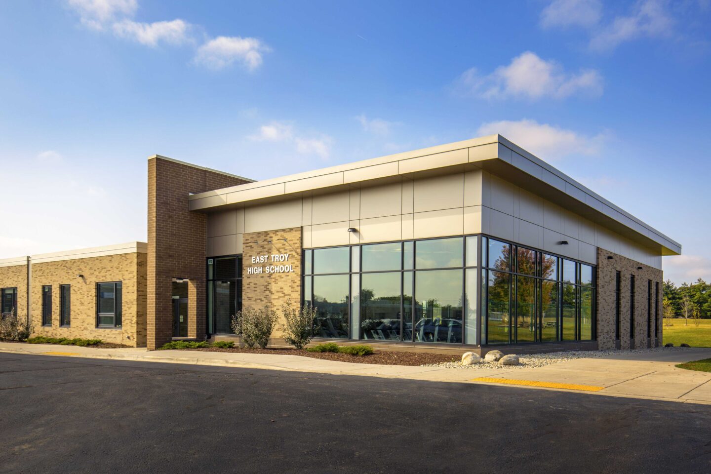 Exterior view of a windowed athletics addition to East Troy High School