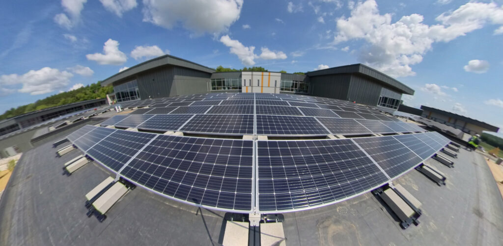 Solar panels stretch in front of the camera using a wide-angle lens on the rooftop of Forest Edge Elementary School