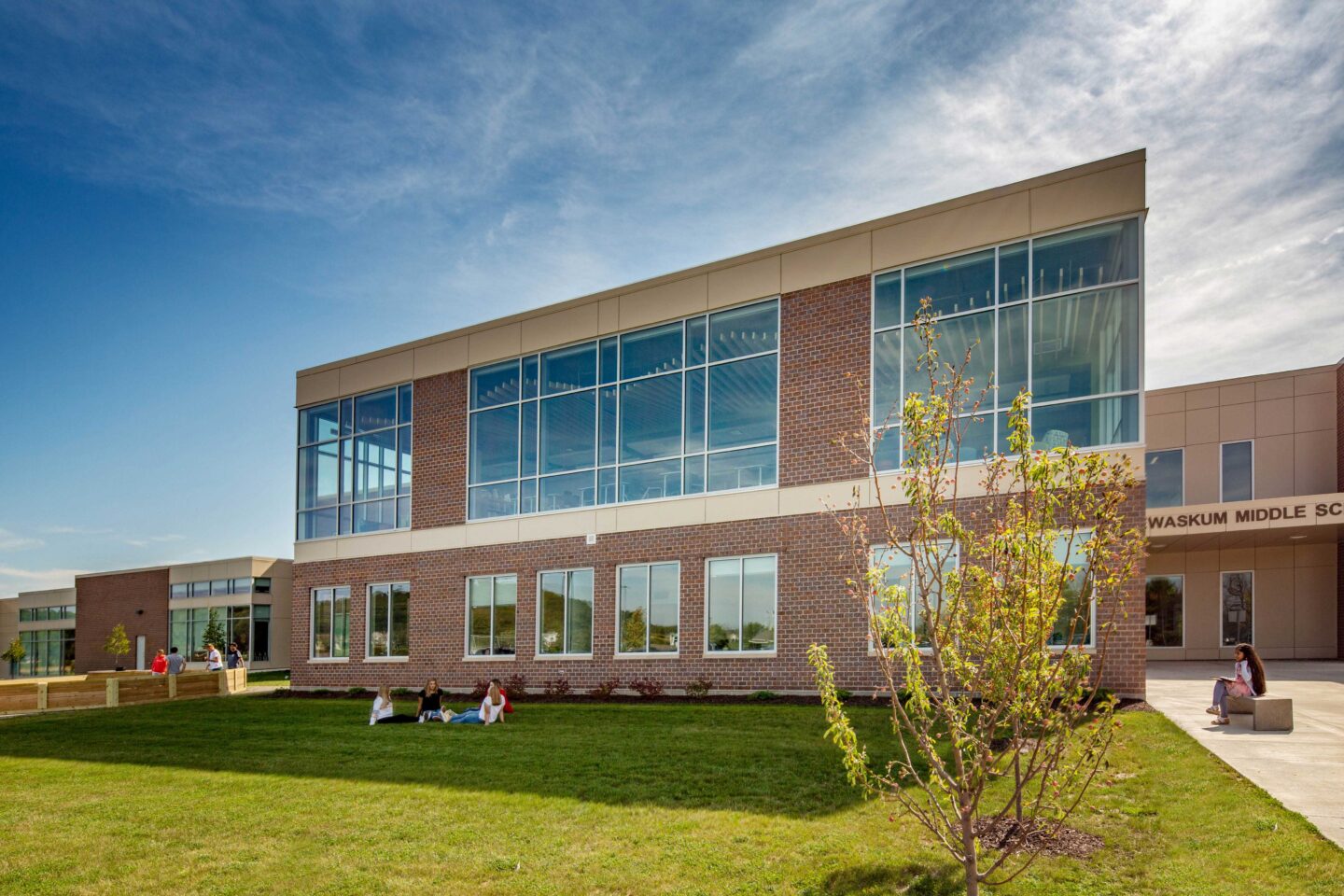 An exterior view of the school, including a glimpse of the main entrance and the library windows