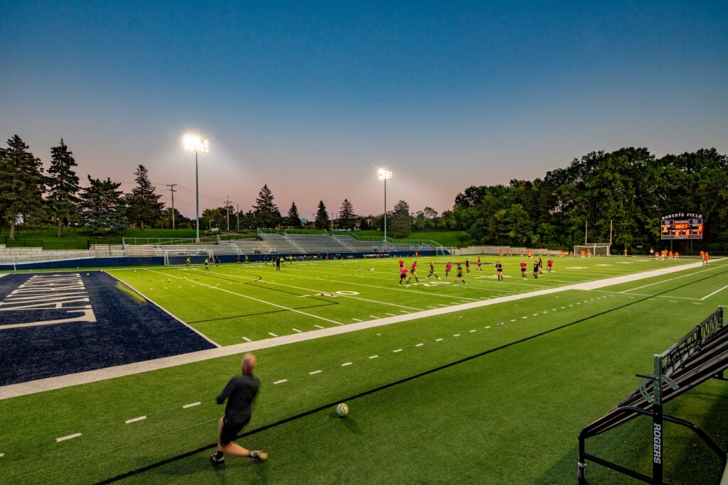 View from a corner of the football field as athletes practice at dusk