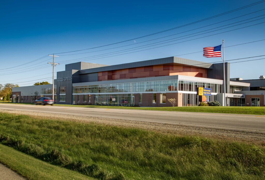 Wide view of a like-new high school featuring large windows and decorative rectangles beneath the roofline