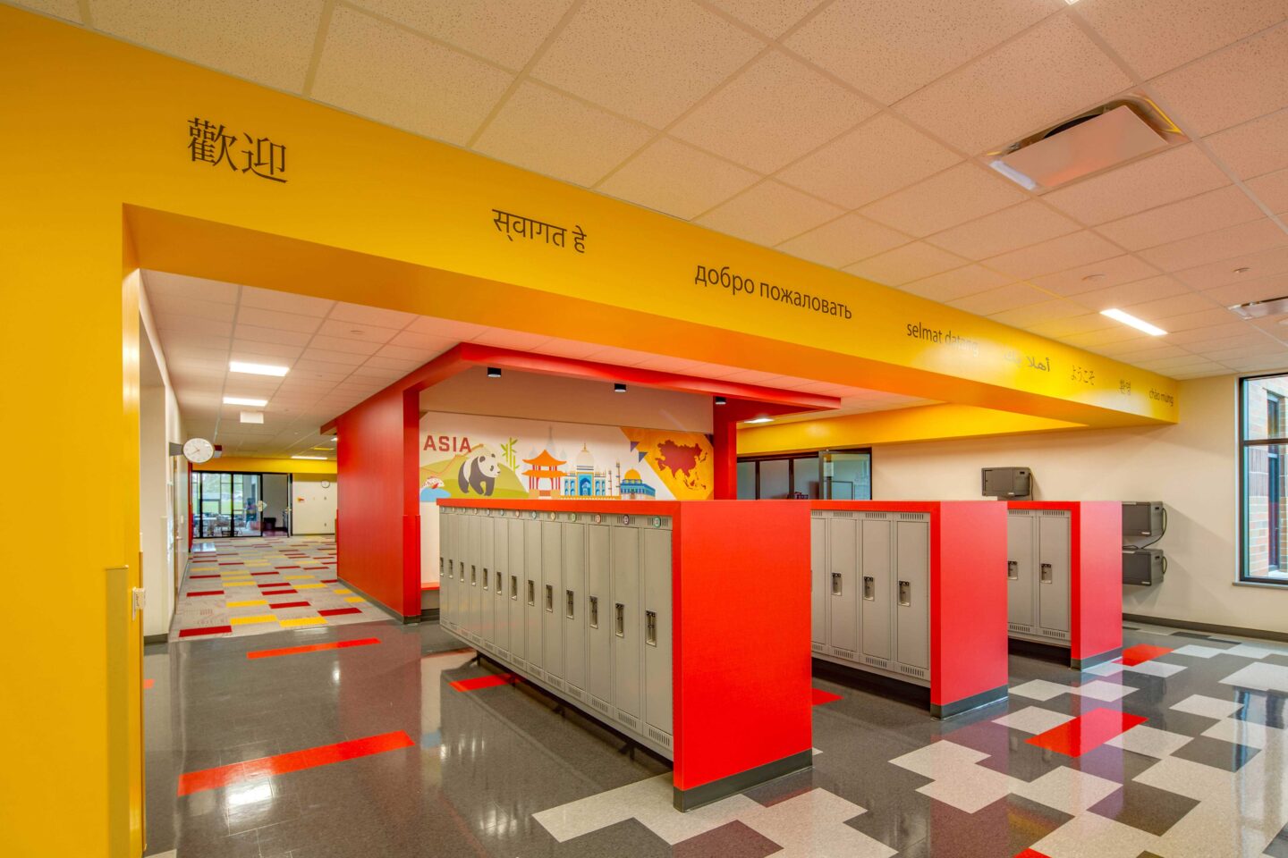 A view of a student locker area featuring an environmental branding installation inspired by the languages, buildings, animals, and plants of Asia