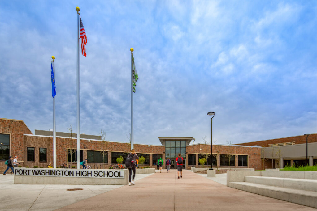 Students walk past the flag poles outside of the school's main entrance