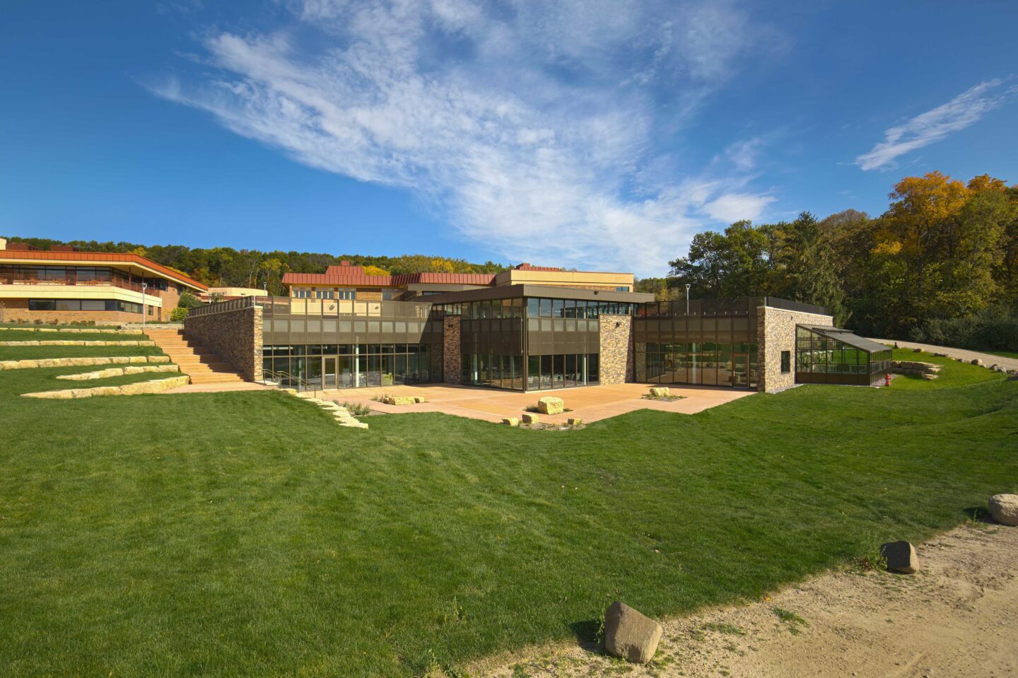 A low building is nestled into the hilly natural landscape