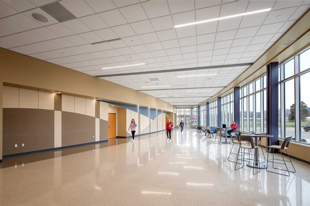 A wide lobby hallway is filled with natural light in the performing arts center