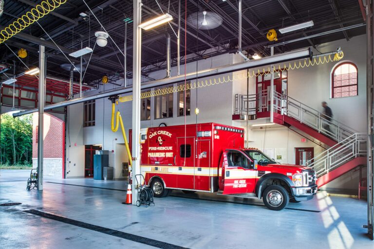 A paramedic truck is parked inside an open bay with stairs leading to living and administration spaces in the City of Oak Creek