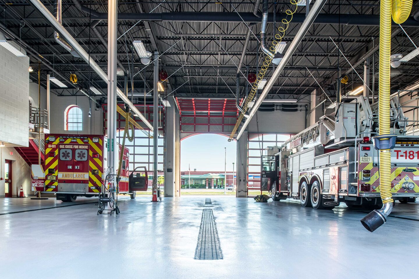 Interior view of a fire station garage with large, open bays leading to the outside at the City of Oak Creek