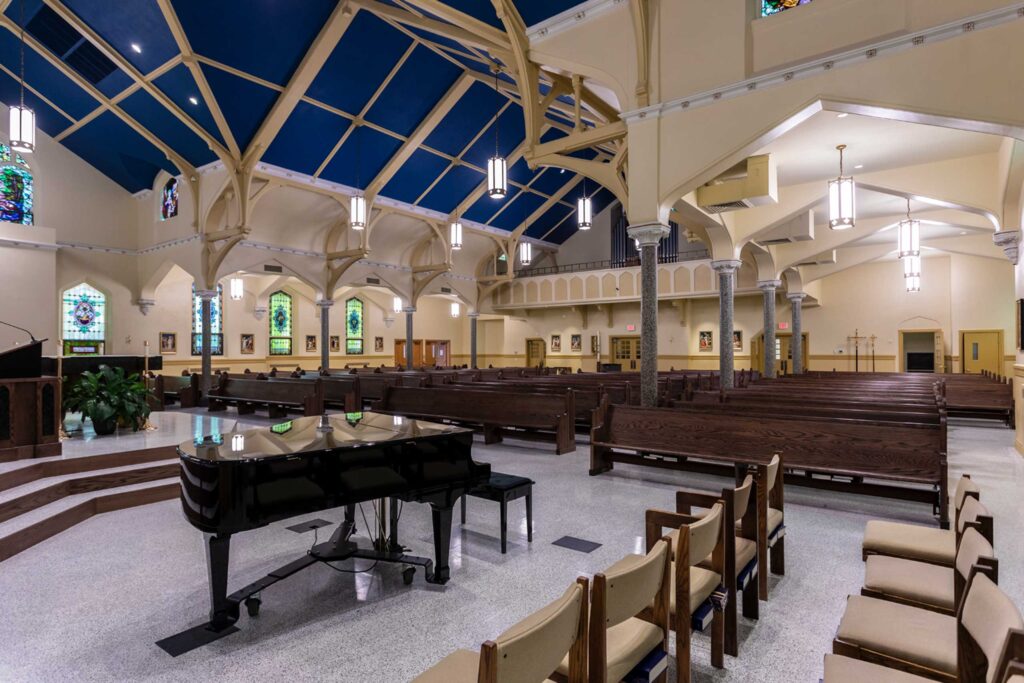 Piano in the foreground of a wide view of the church interior