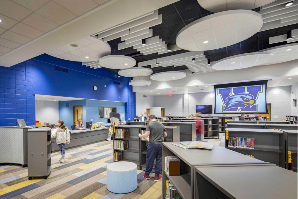 An open library with low shelves connects to a resource desk at Wheatland Center School