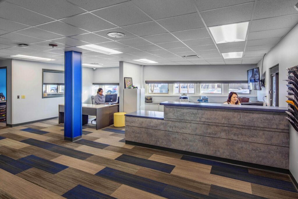 Windows line a reception and office area with ample space for approaching visitors at Wheatland Center School