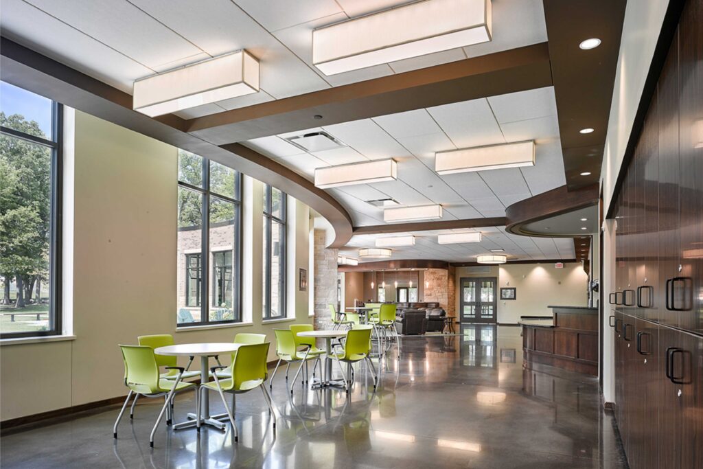 Bistro seating with pops of color line a community space filled with natural light