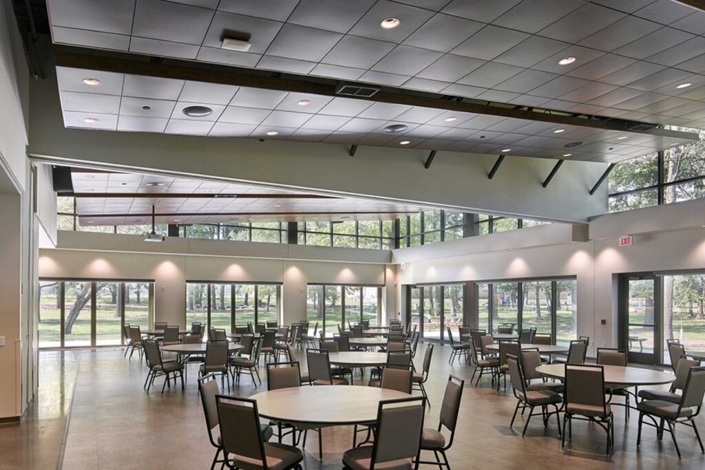 Tables dot an open event space with high ceilings and large windows