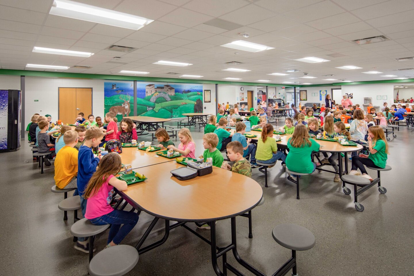 A mural and accents with school colors brighten up the elementary school cafeteria at the Coleman School District