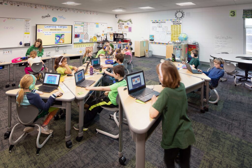 An open classroom with adjustable tables creates a flexible space as Coleman Elementary School students work at laptops