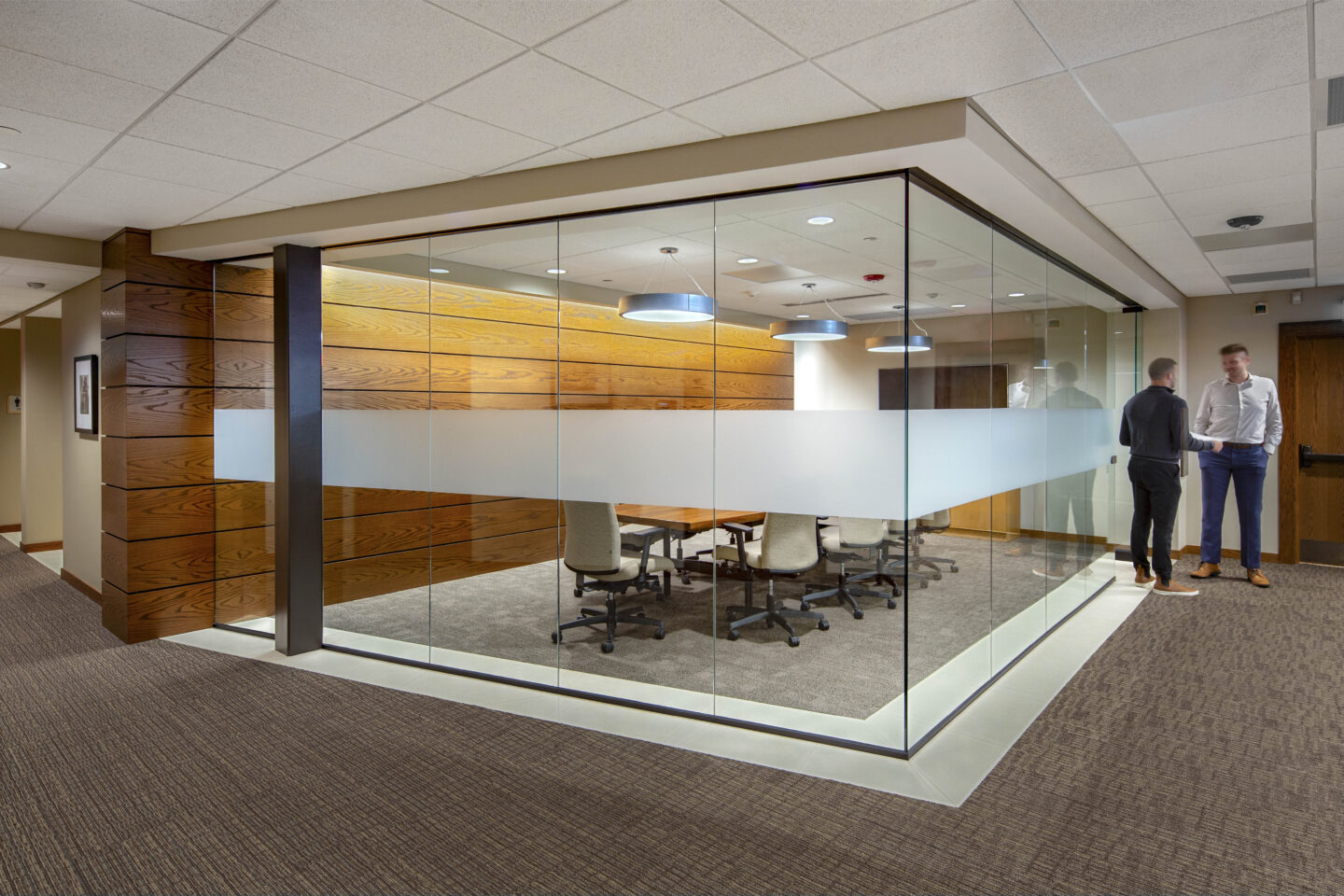 A frosted stripe envelops an all-glass conference room