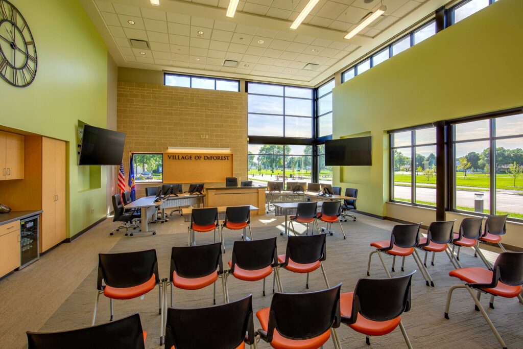 Windows and stone accent walls of a high-ceilinged village meeting room in DeForest