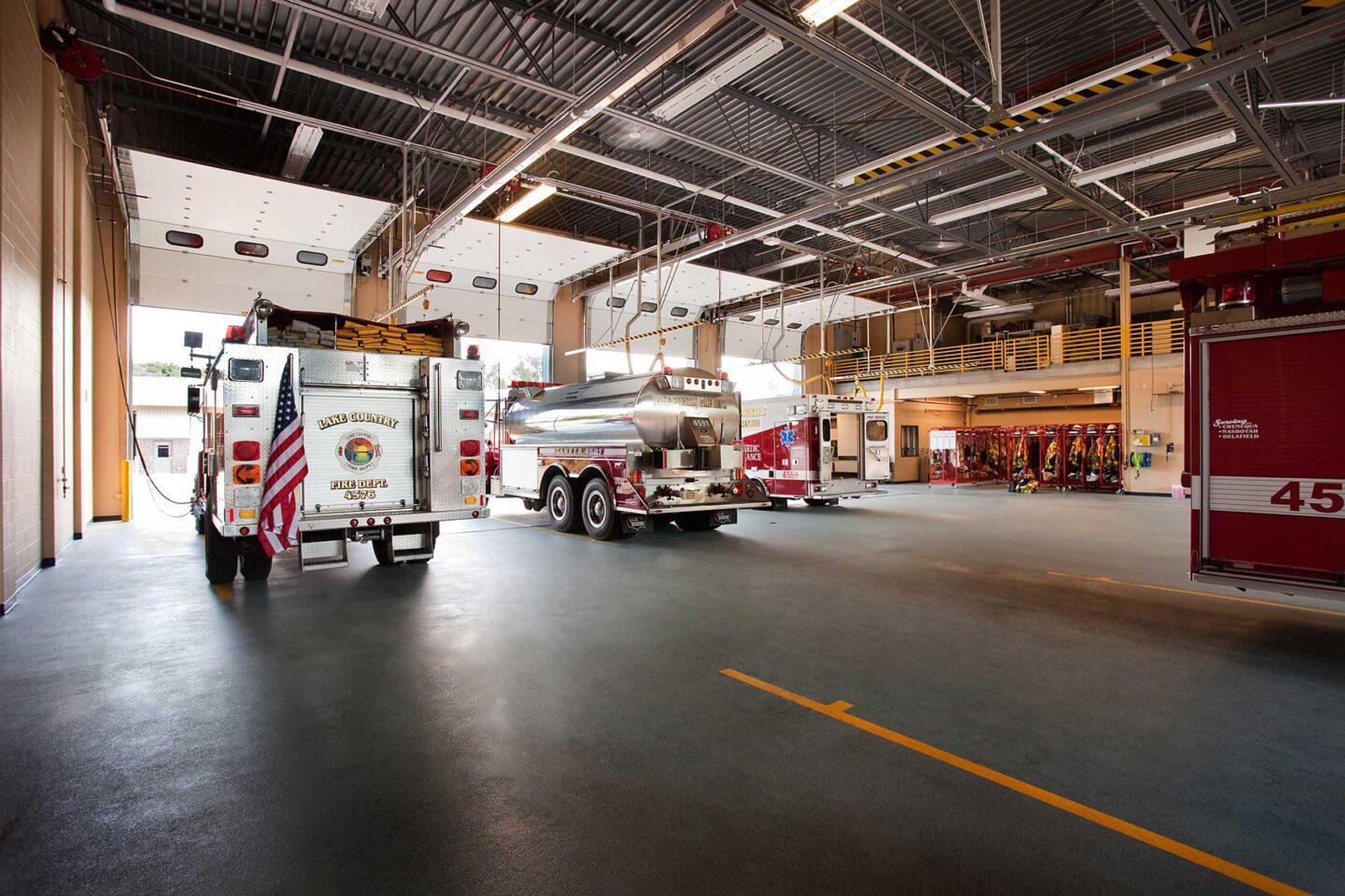 Interior view of fire response vehicles facing away toward open bays in the Delafield Public Safety Building