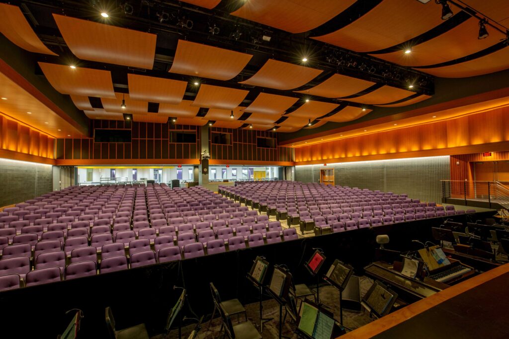 A view of the renovated auditorium from the stage looking back at the opened partition wall that allows the adjacent cafeteria to be used as overflow seating.