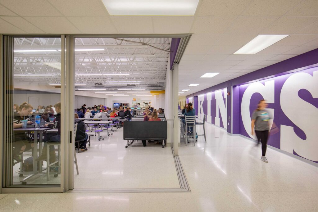 A view of the sliding glass panels between the cafeteria and circulation spaces, creating more flexibility for using these spaces