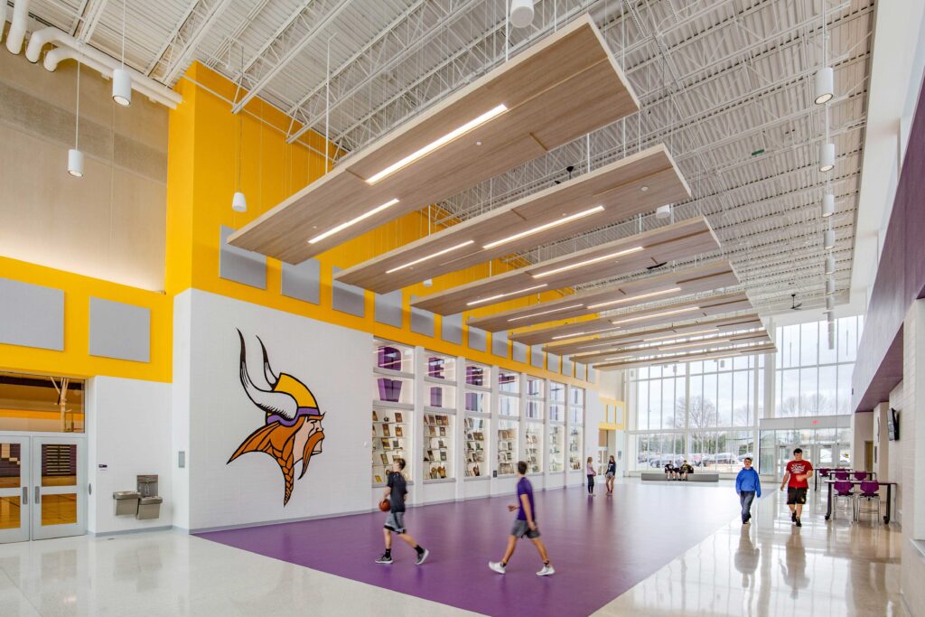 A view of the new lobby, which features large windows, trophy cases, and wood-veneered lighting panels