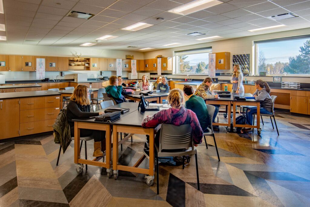 Flexible tables are arranged into small groups for students working in an updated lab at Florence Middle + High School