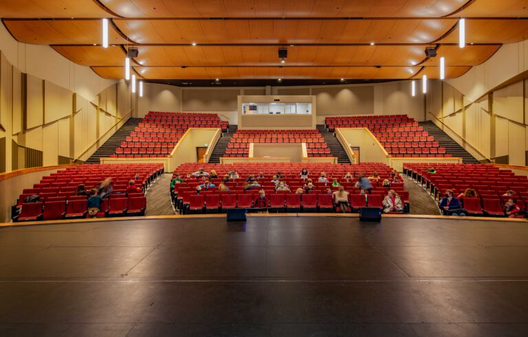 View from the stage as students occupy seats in a rolling auditorium