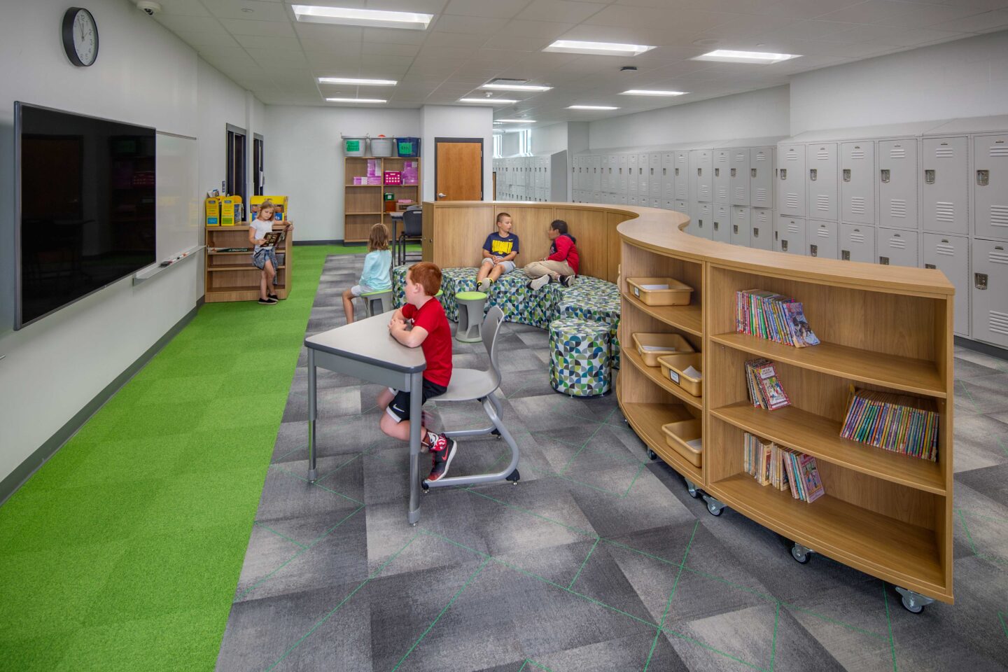 Low, curving shelves and flexible furniture add collaboration spaces off of hallways at Highland View Elementary in Greendale
