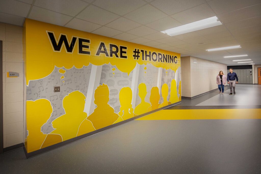 A large mural in a corridor reading "We Are #1Horning" shows school pride at Waukesha's Horning Middle School