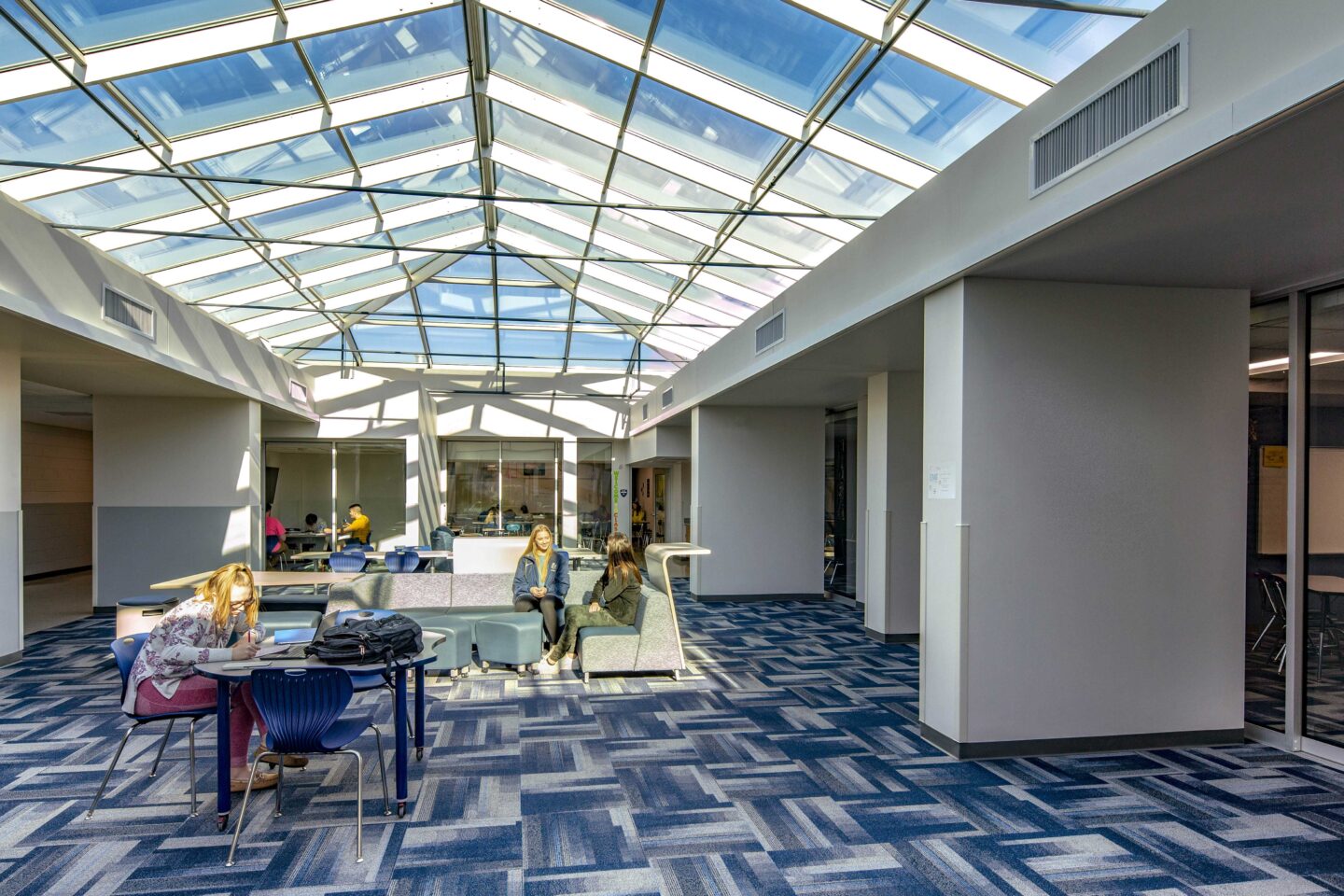 A large skylight brightens an open collaborative space connecting classrooms at Hudson High School