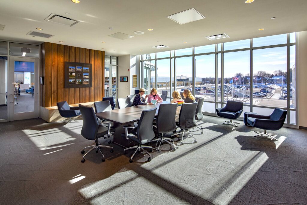 Light floods a conference room with modern wood accents at Hudson High School