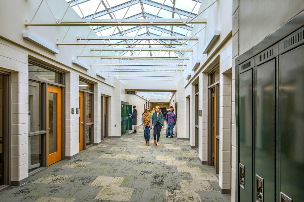 Students walk to their next class in one of the school's renewed corridors, which features a large skylight for natural light