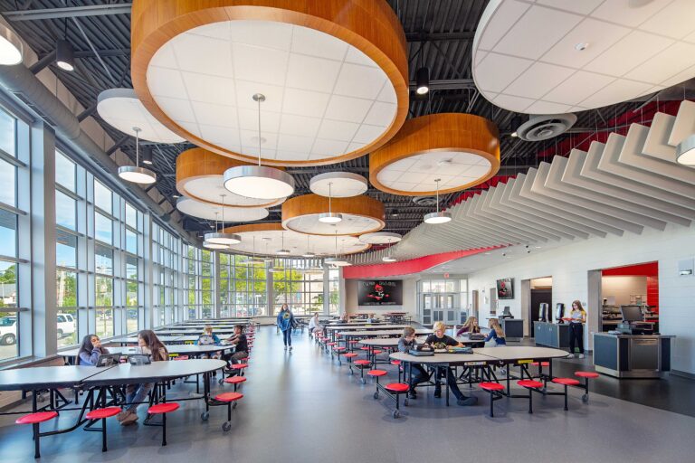 Drum-shaped light fixtures and a wall of windows create a bright environment at the Les Paul Middle School cafeteria in Waukesha