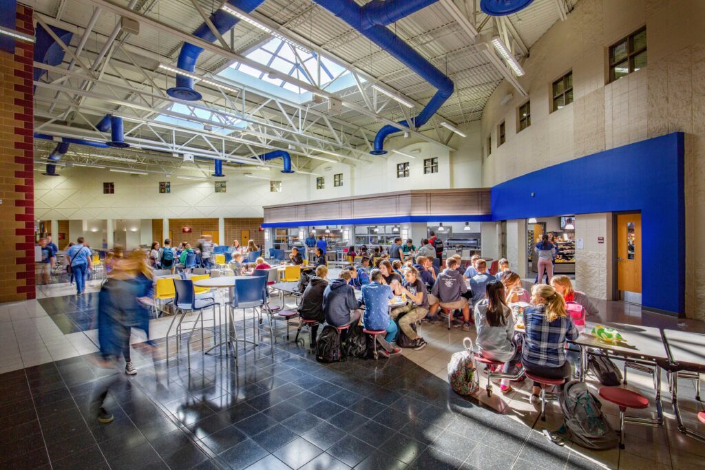 Vaulted ceilings and skylights create a bright and spacious cafeteria space at Little Chute Intermediate, Middle, and High School