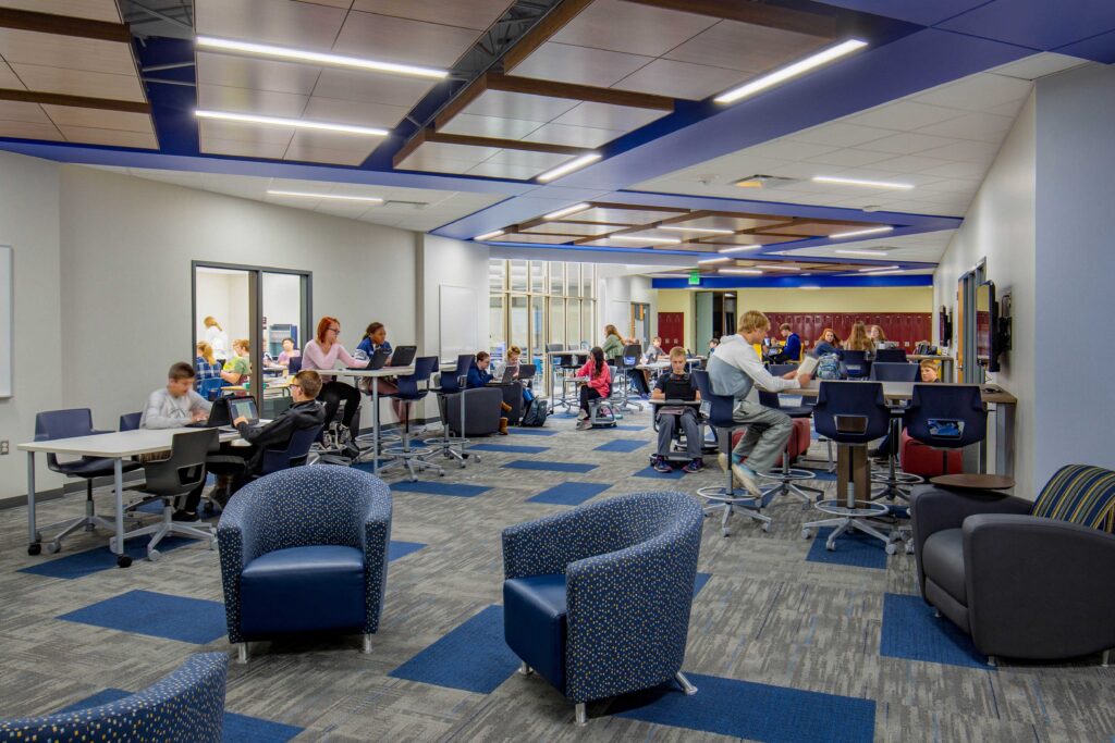 Connected to a hallway and classrooms, a comfortable collaboration space offers multiple furniture options where students gather at Little Chute Intermediate, Middle, and High School