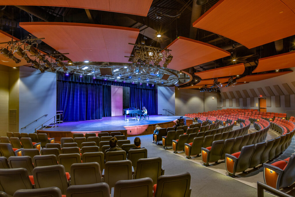 A student rehearses at the piano in the renovated performing arts center