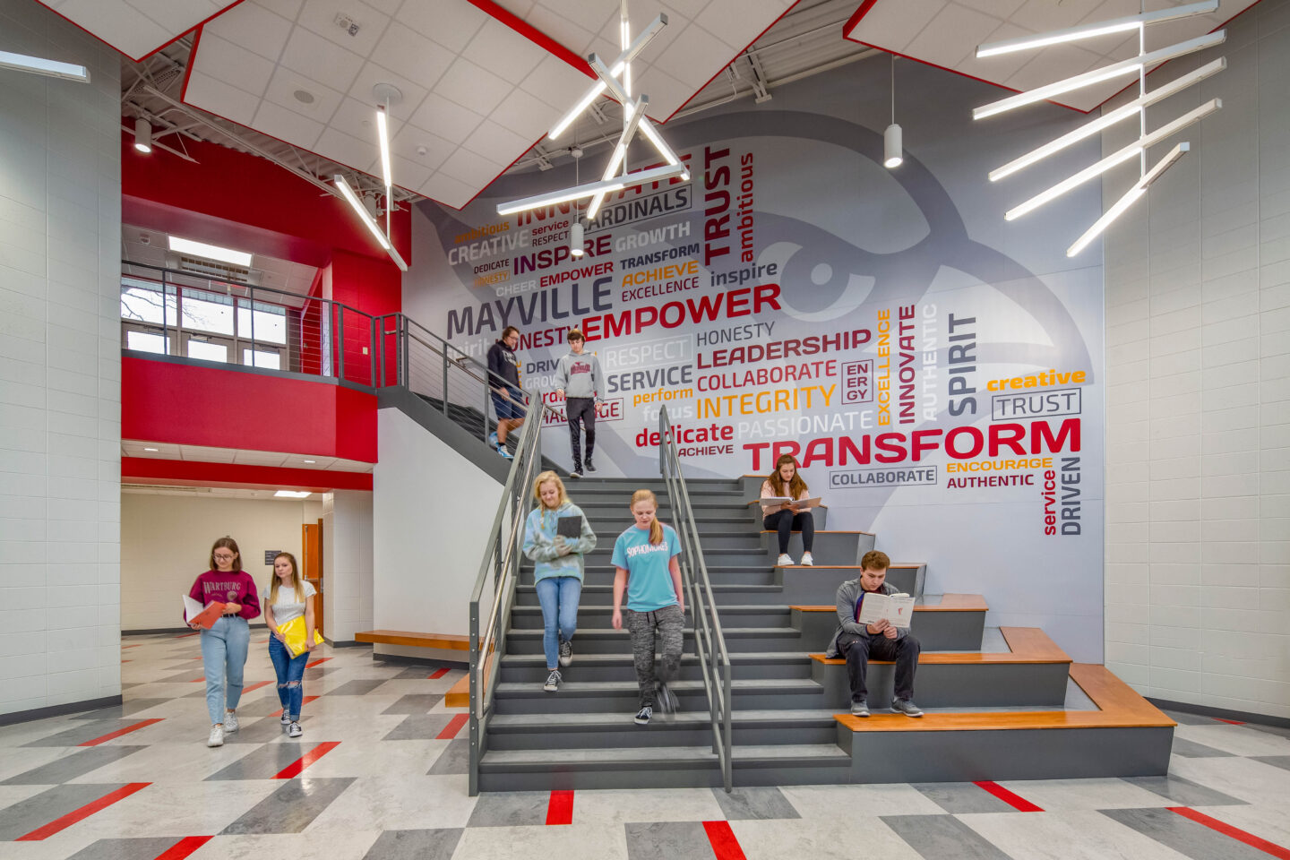 Students at the learning stair with a large environmental branding graphic of word clouds in the background