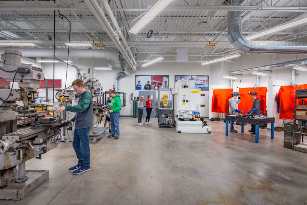 Students work in renovated tech ed labs that include large machinery and welding booths.