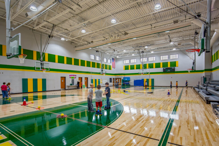 Students play in a large gym set up for multiple activities at Melrose-Mindoro School District