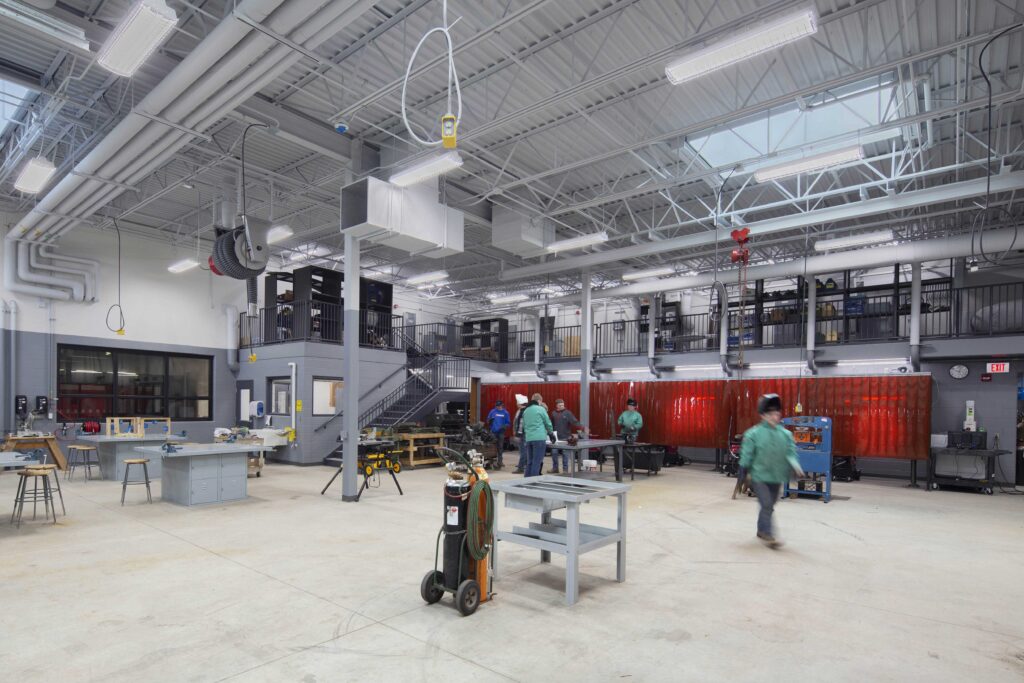 Students work in the school's large welding shop complete with a view of the welding booths and upper mezzanine