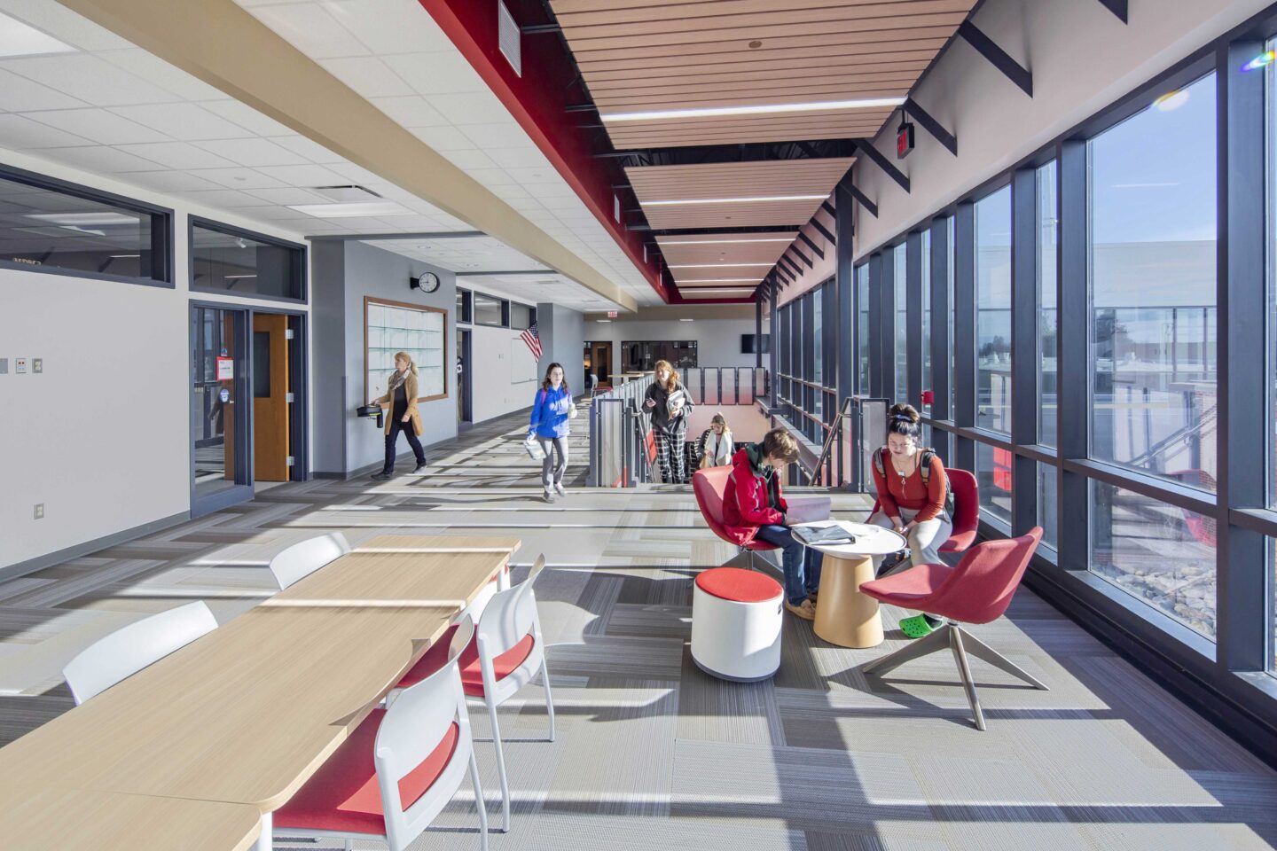 Students make use of the well-lit second floor landing area thanks to large, floor-to-ceiling windows along the adjacent corridor